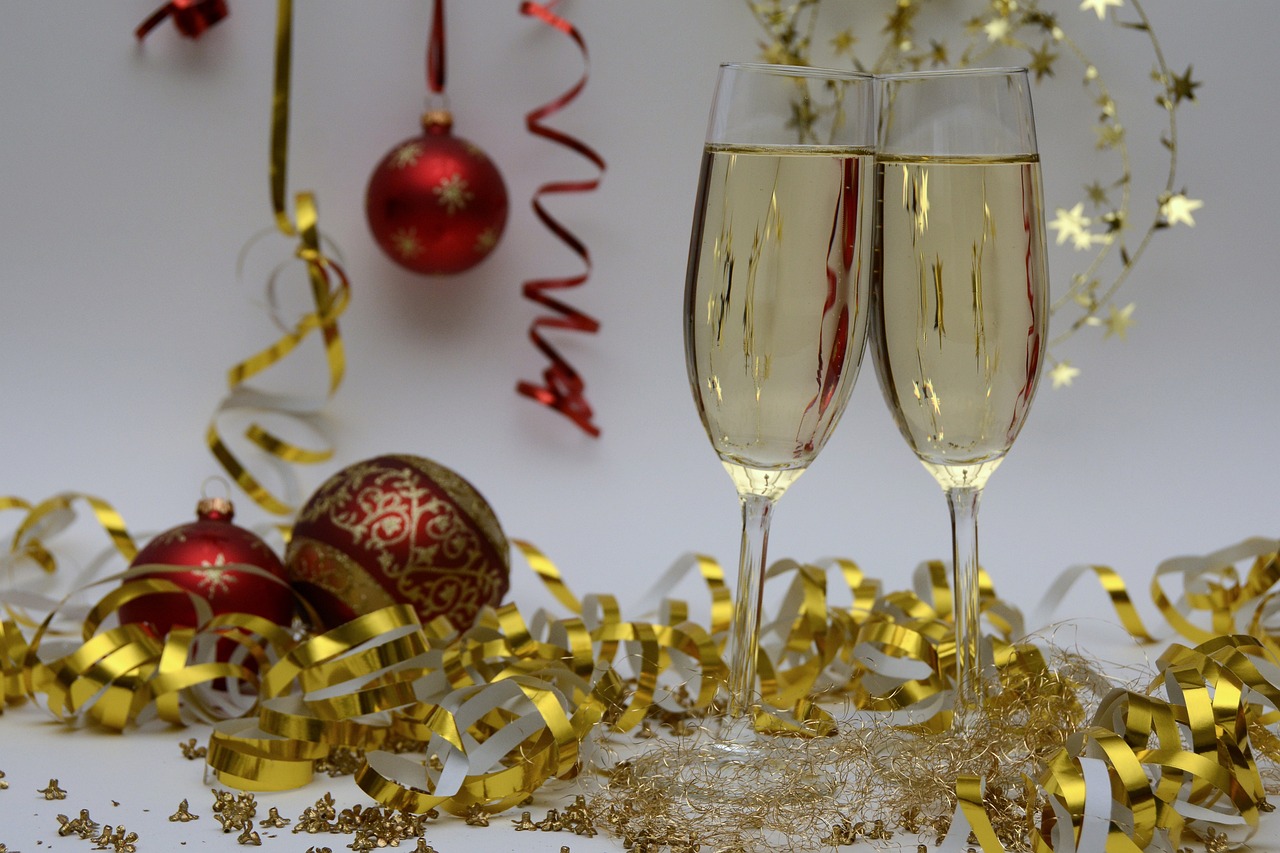 red christmas ornaments with yellow tinsel. Two glasses of Champagne