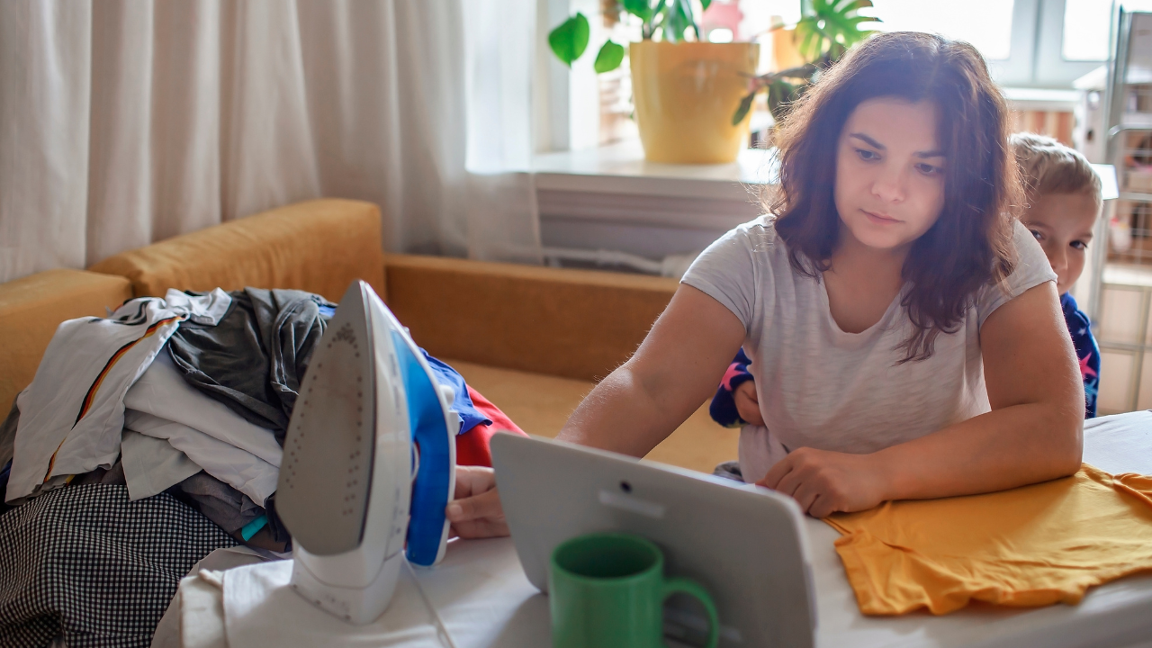 a woman sitting attending to laundry, working and being a caregiver